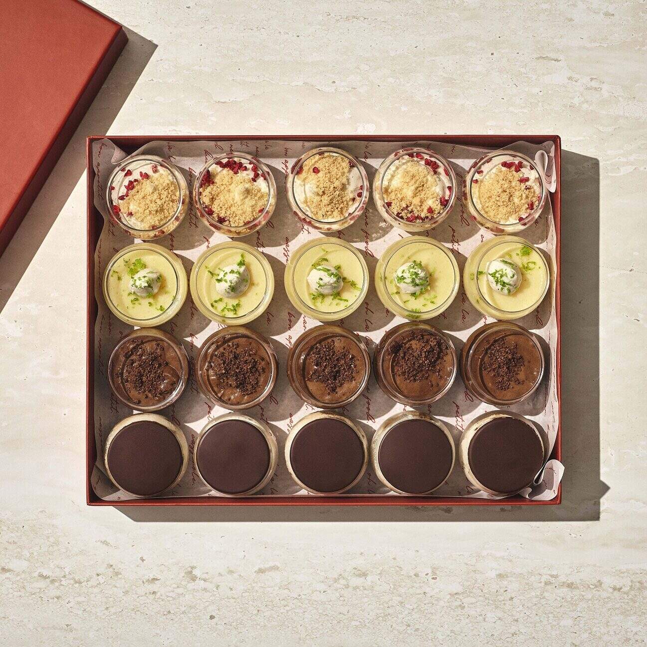 קופסה של מיקס מוסים עם 16 קינוחים מיני מסוגים שונים, מסודרים בארבע שורות, כל אחד עם טעם או ציפוי שונה. - Cassarole